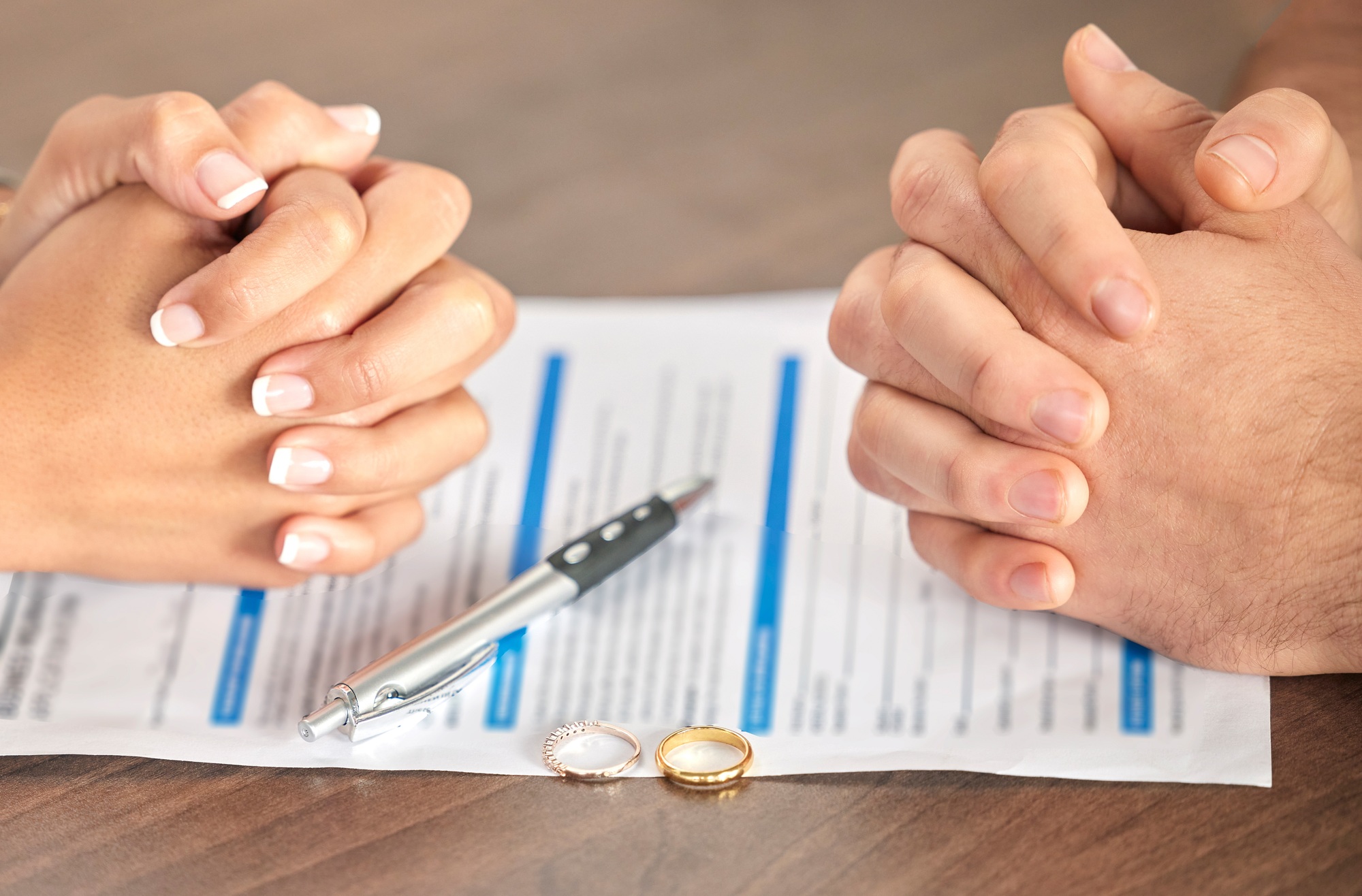 Divorce, signing and hands of a couple with a document for court, deal and legal paperwork. Togethe