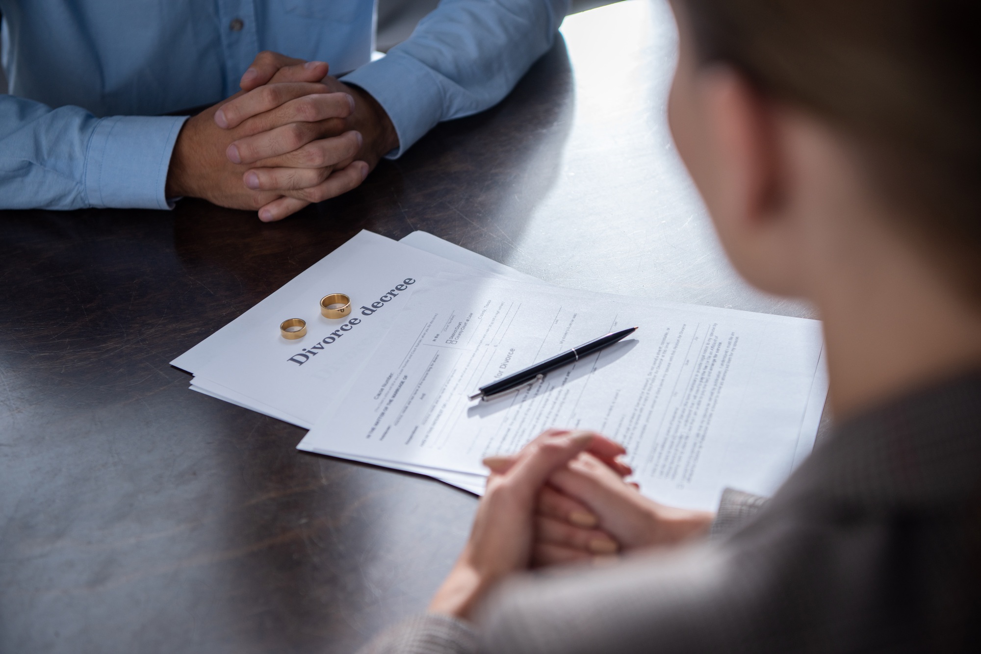 partial view of couple at table with divorce documents