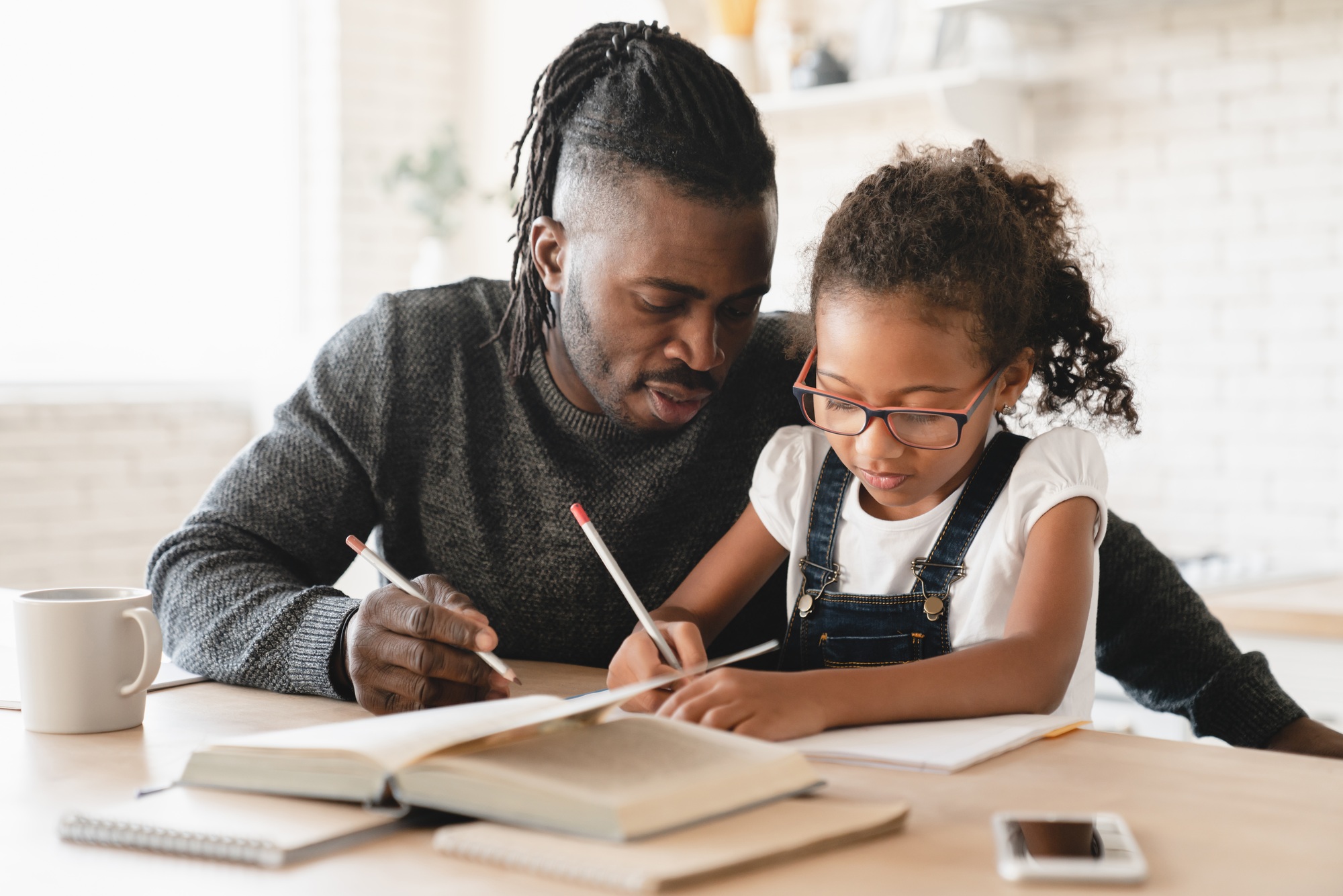 Tutoring homeschooling. Dad helping daughter with homework, drawing together, e-learning