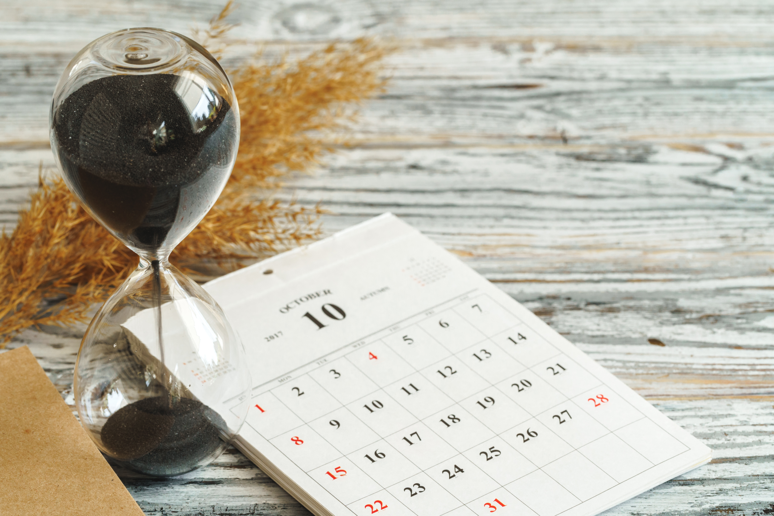 hourglass-with-calendar-on-wooden-desk-close-up