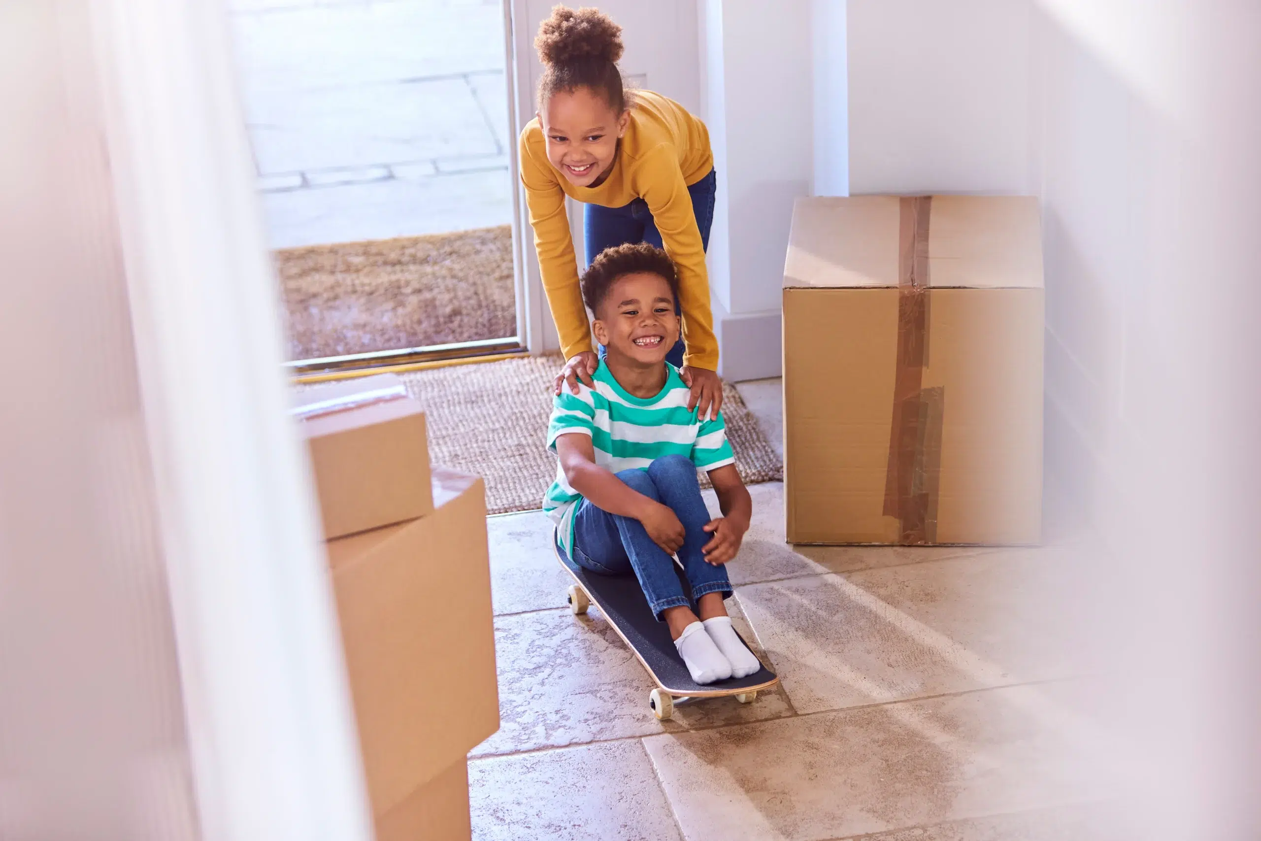two children playing with moving boxes during relocation