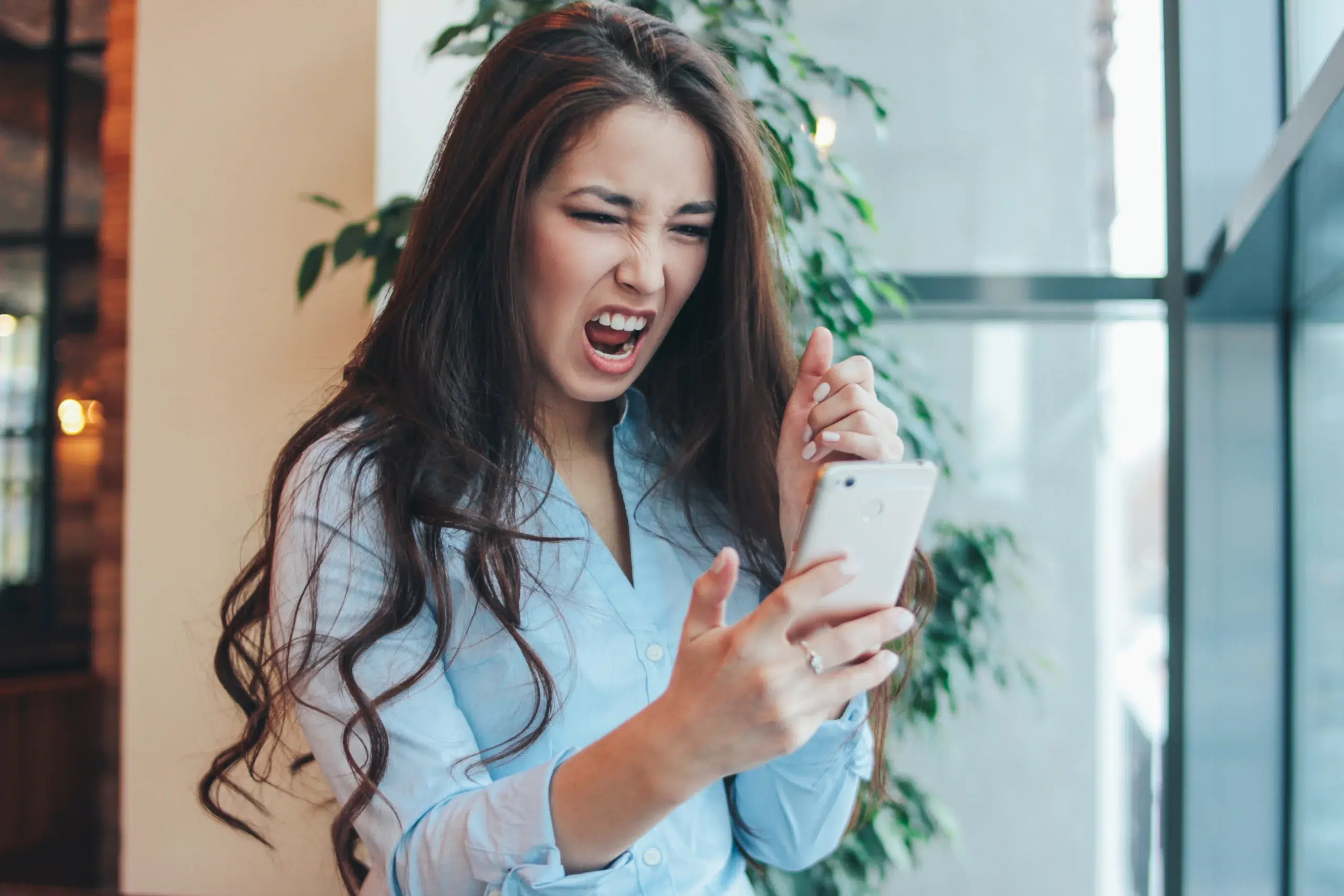 angry woman looking at her cell phone